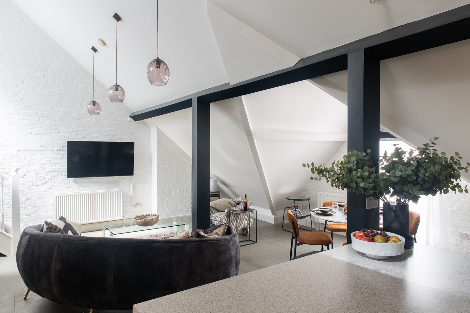 Luxury apartment living room with dark structural beams and pendant lights